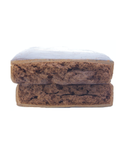 Rectangular block of compressed brown material with a rough, uneven surface texture photographed on a plain background.