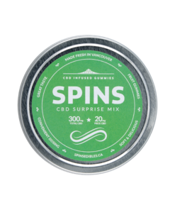 Round container lid featuring SPINS branding with a green color scheme and product labeling photographed on a plain background.