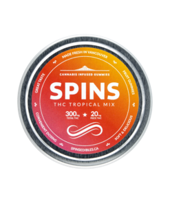 Round container lid featuring SPINS branding with an orange and red gradient design and visible product labeling on a plain background.