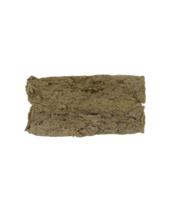 Rectangular piece of compressed brown material with an uneven surface and slightly rough texture photographed on a plain background.
